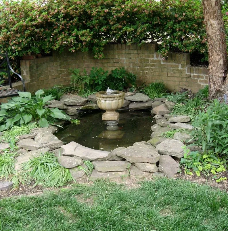 Пруд с фонтаном в саду